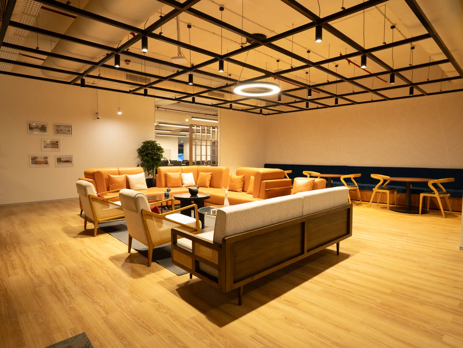 Breakout lounge with orange sofas and exposed ceiling grid — Moschip
